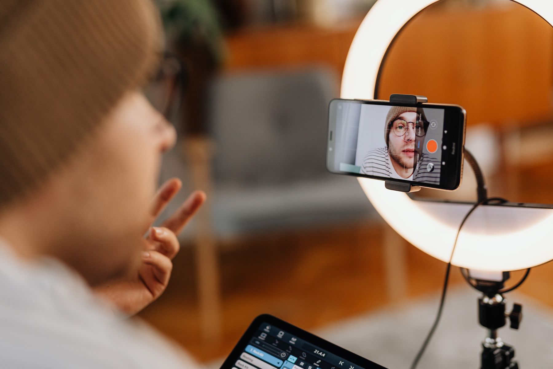 Criador gravando um vídeo com o celular e luz circular